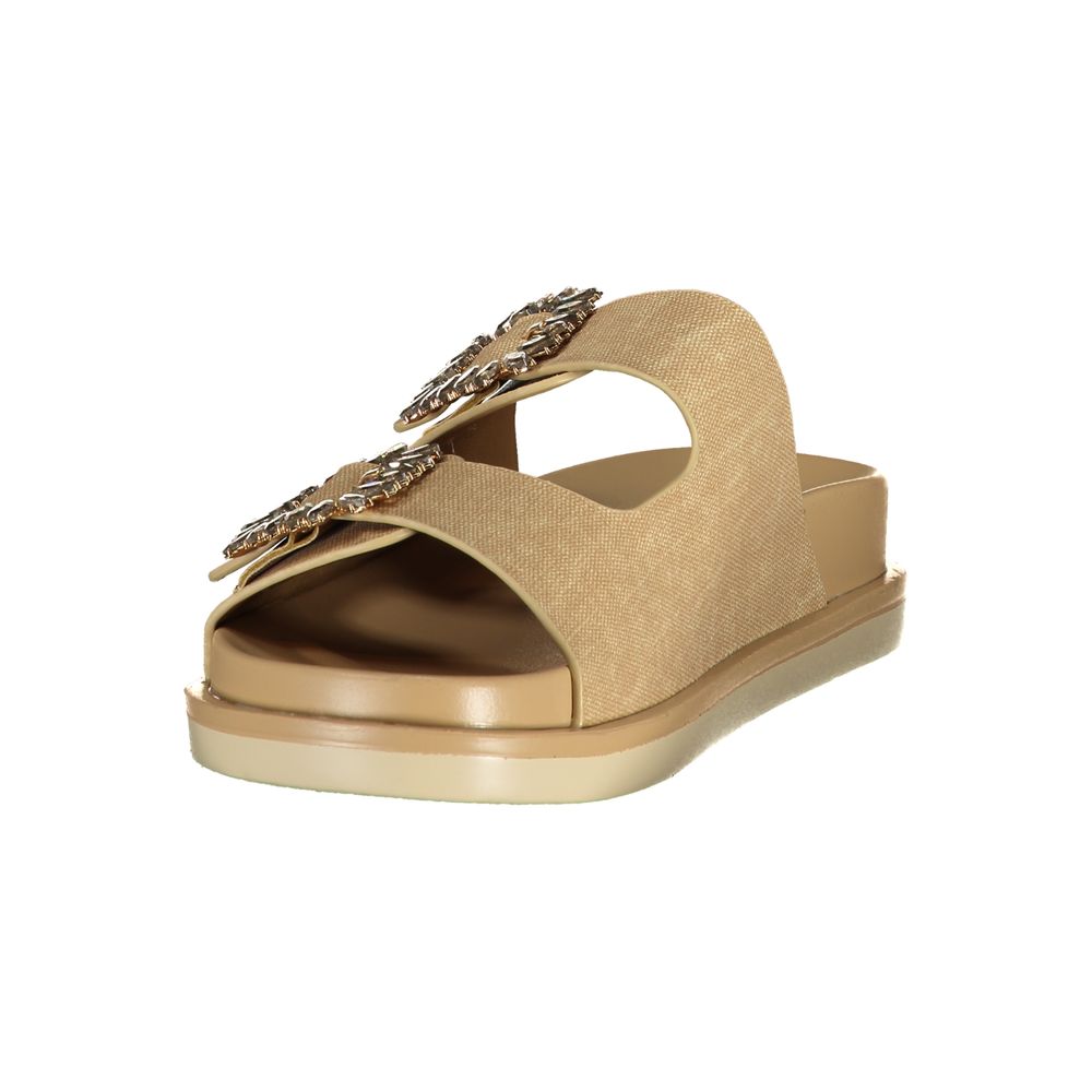 Female model wearing Laura Biagiotti gold polyurethane women's sandal with two wide shimmer straps featuring ornate jewelled buckle embellishments, a cushioned flatform sole, and refined Italian craftsmanship, captured mid-step in a casual lifestyle pose showcasing the sandal's glamorous golden opulence and effortless designer luxury.