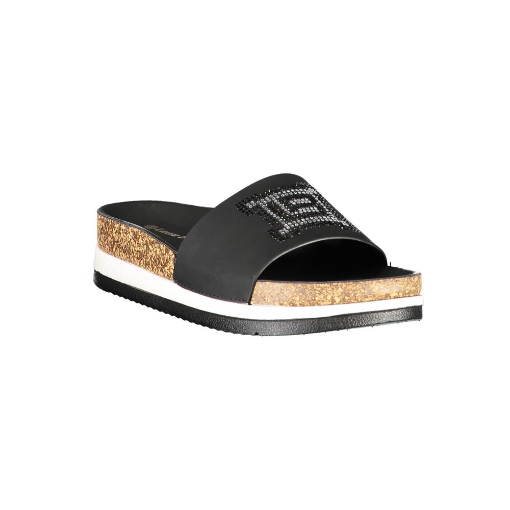 Female model wearing Laura Biagiotti nero black polyurethane women's slipper with a sleek black upper, effortless slip-on silhouette, and refined Italian craftsmanship, captured mid-step in a casual lifestyle pose showcasing the slipper's understated sophistication and relaxed everyday luxury.