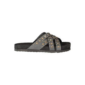 Black polyurethane women's slide sandal with crisscross straps and gold stud embellishments on a flat footbed.