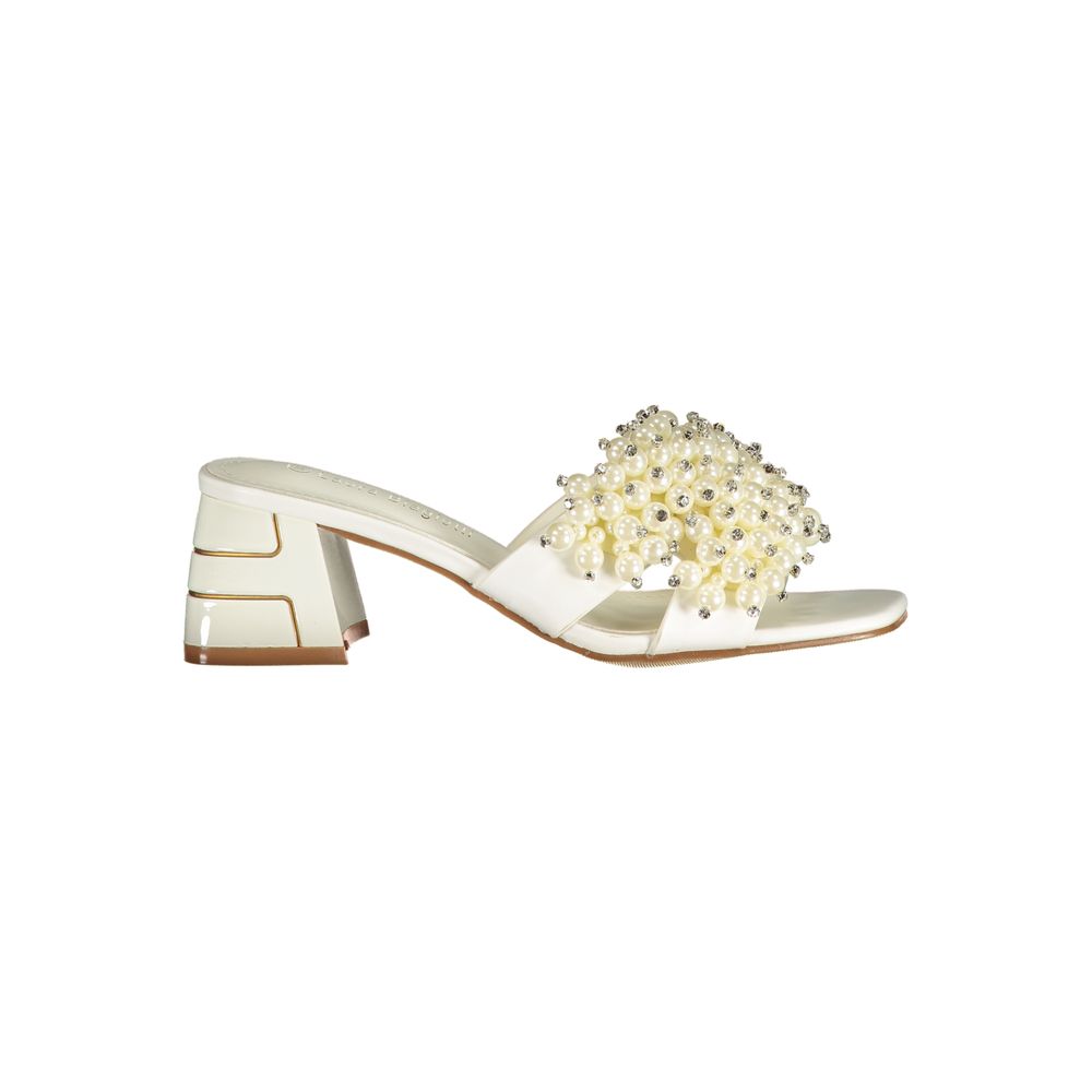 Female model wearing Laura Biagiotti bianco white polyurethane women's sandal with a crisp white upper, elegant strap detailing, and refined Italian craftsmanship, captured mid-step in a casual lifestyle pose showcasing the sandal's clean summer brightness and effortless designer elegance