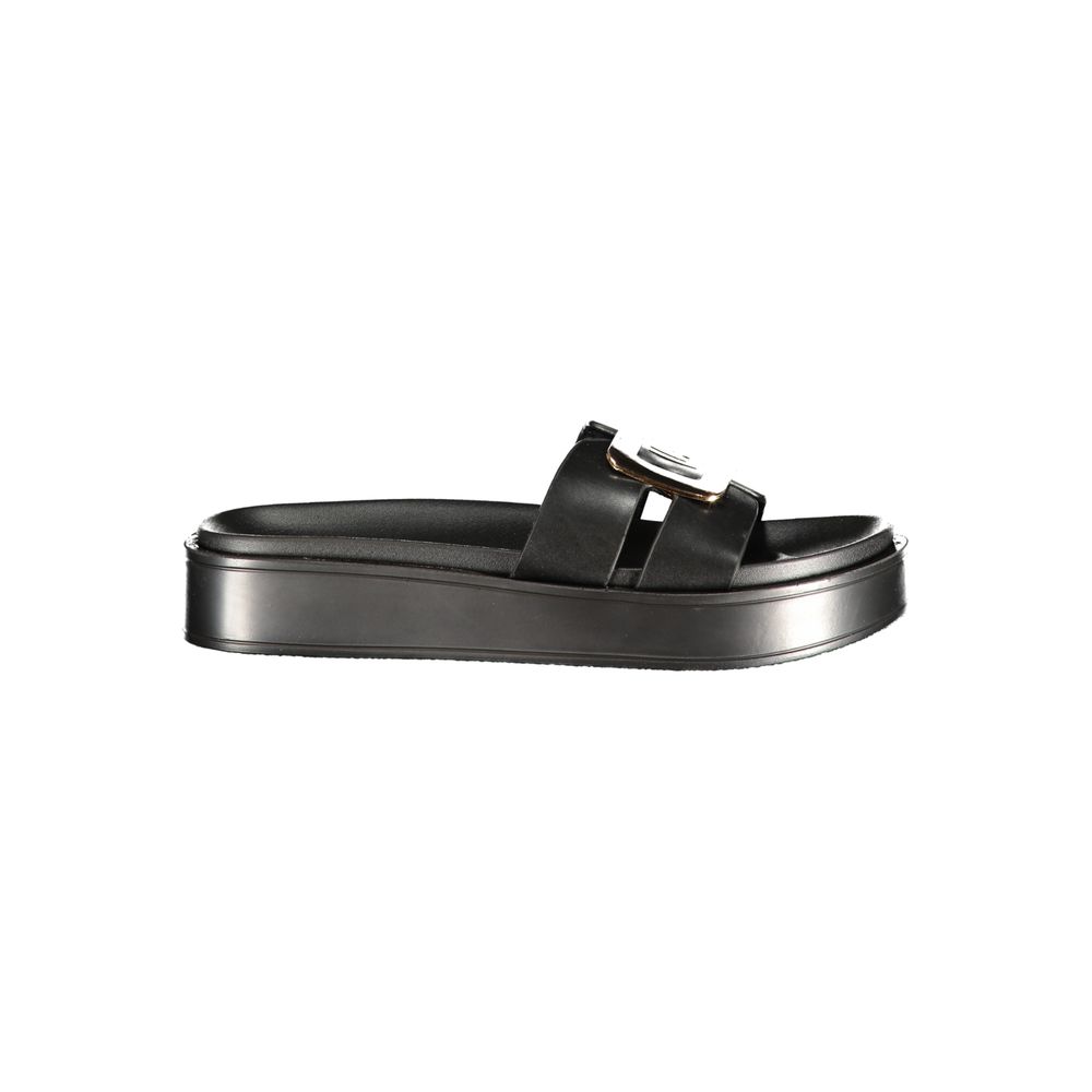 Female model wearing Laura Biagiotti nero black polyurethane women's sandal with a sleek black upper, elegant strap detailing, and refined Italian craftsmanship, captured mid-step in a casual lifestyle pose showcasing the sandal's understated sophistication and effortless designer style