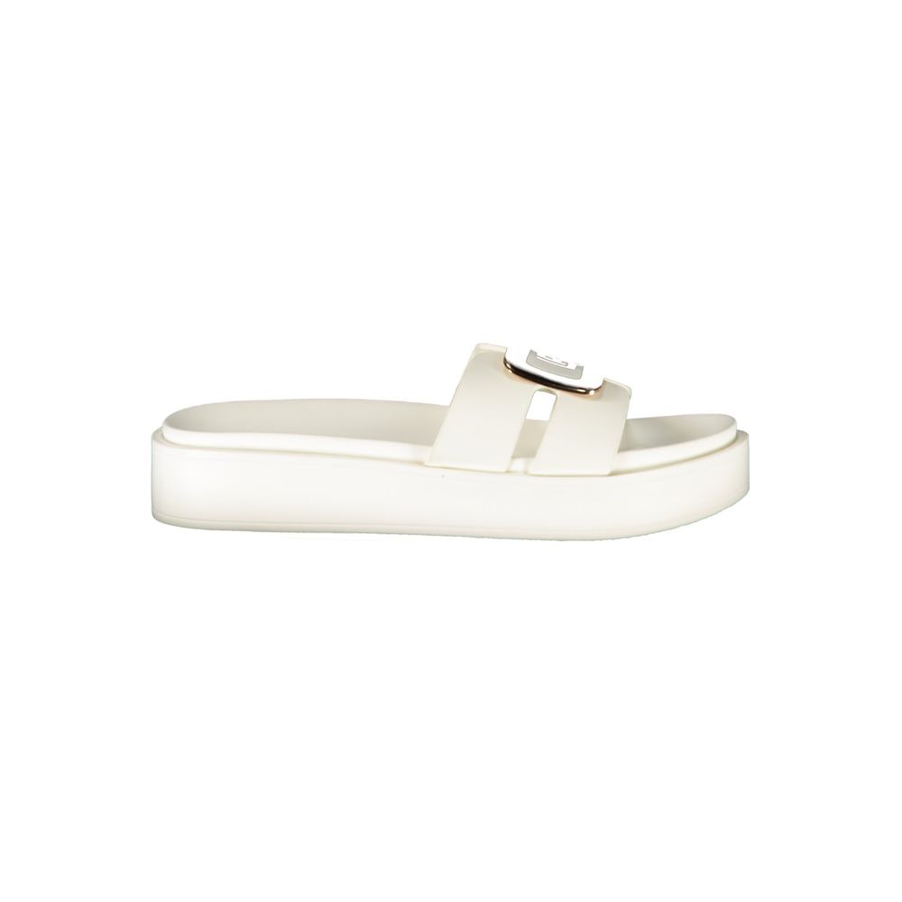 Female model wearing Laura Biagiotti white polyurethane women's sandal with a clean white upper, elegant strap detailing, and refined Italian craftsmanship, captured mid-step in a casual lifestyle pose showcasing the sandal's understated sophistication and effortless summer luxury.
