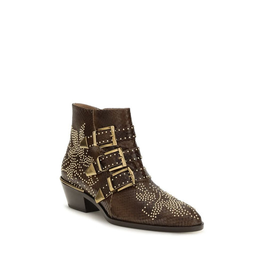Female model wearing Chloé brown calf leather Bos Taurus ankle boots with a rich warm brown leather upper, refined stitching details, and luxurious French designer craftsmanship, captured mid-step in a casual lifestyle pose showcasing the boot's understated earthy elegance and effortless Parisian sophistication