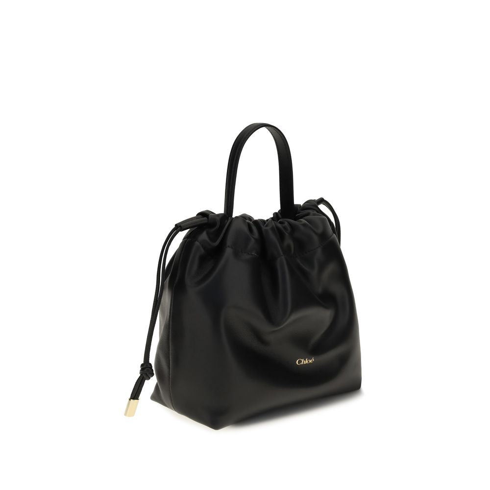 Chloé black leather shoulder bag with a top handle, drawstring closure, and gold-tone logo.