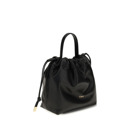 Chloé black leather shoulder bag with a top handle, drawstring closure, and gold-tone logo.