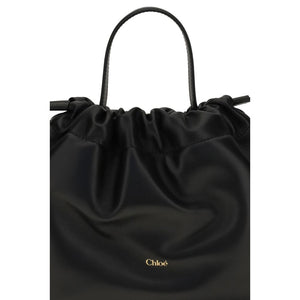Chloé black lambskin leather shoulder bag with a drawstring top, single strap, and gold-foil logo.