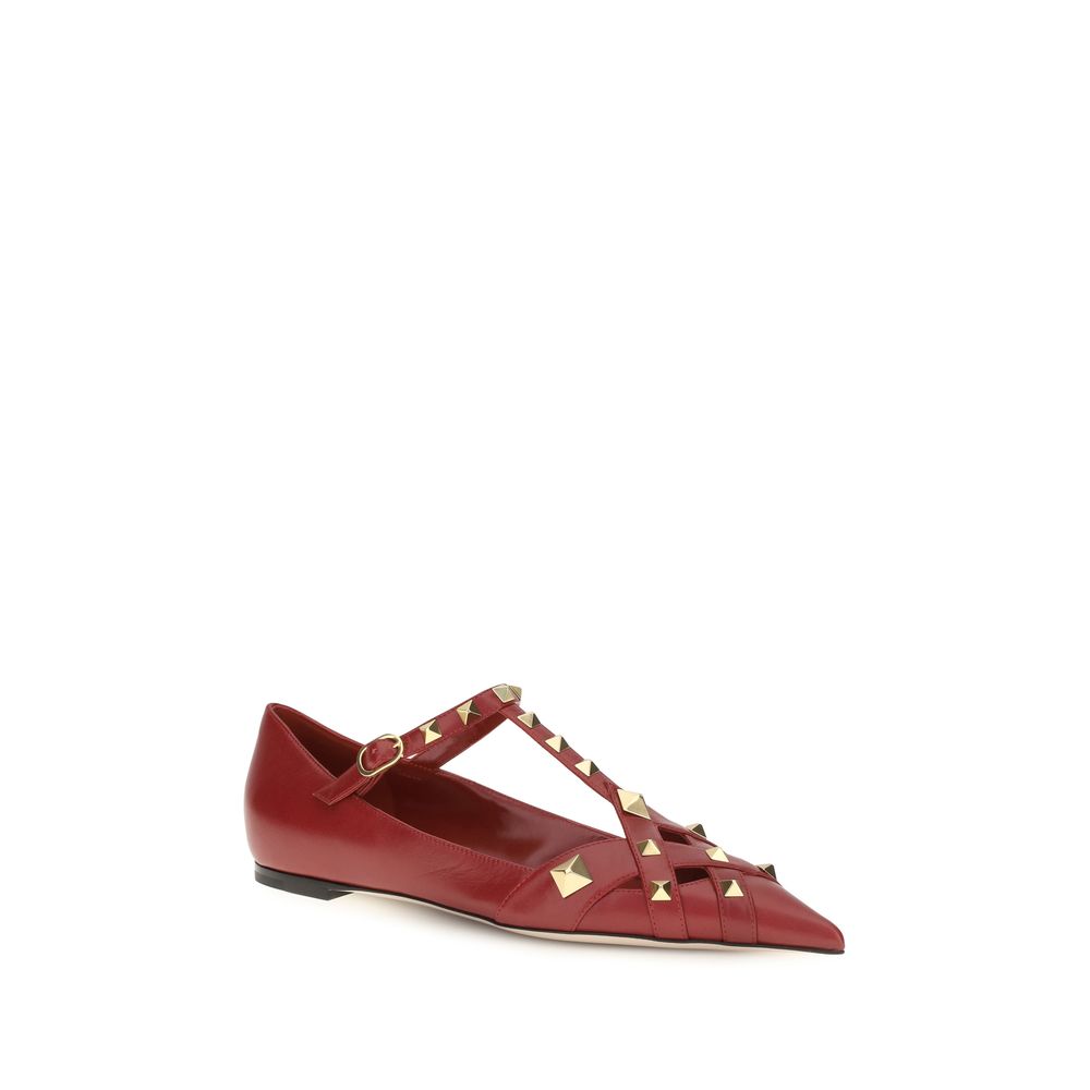 Red flat shoe with gold stud details on a white background
