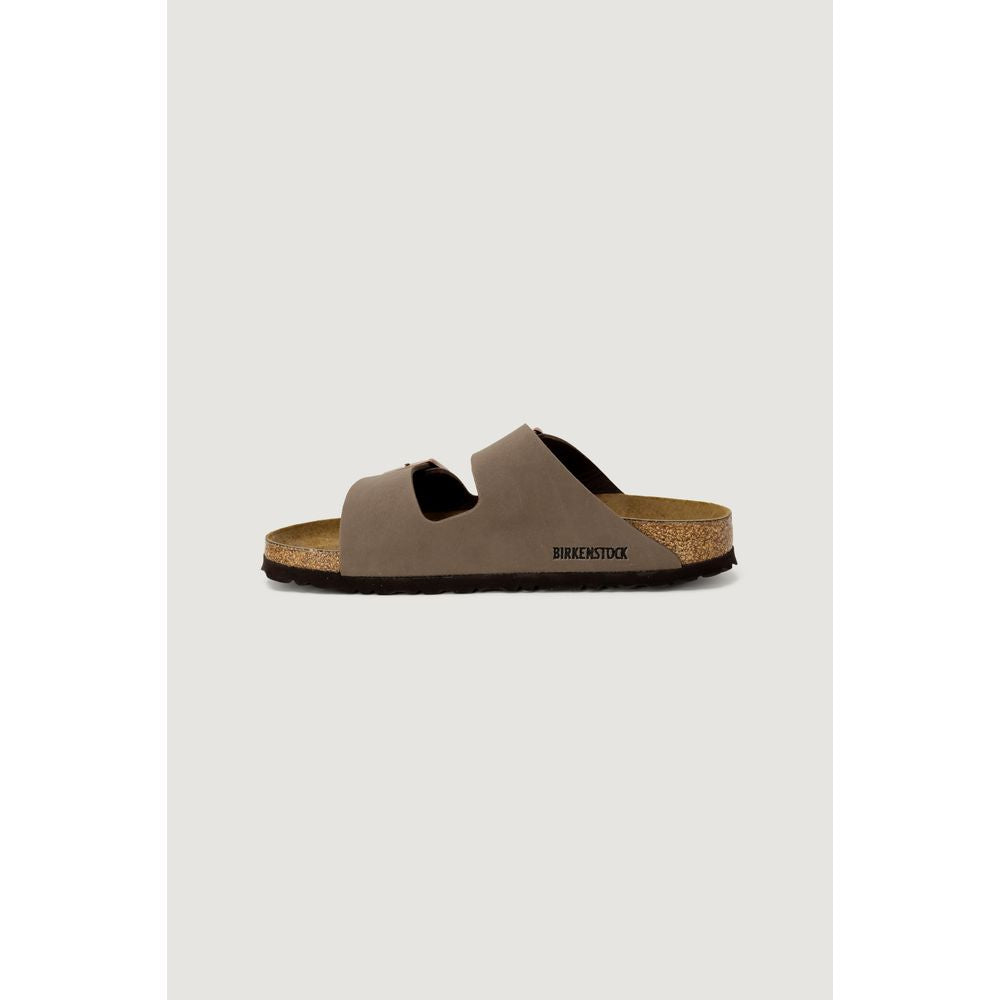 Brown sandal with cork footbed on a light gray background