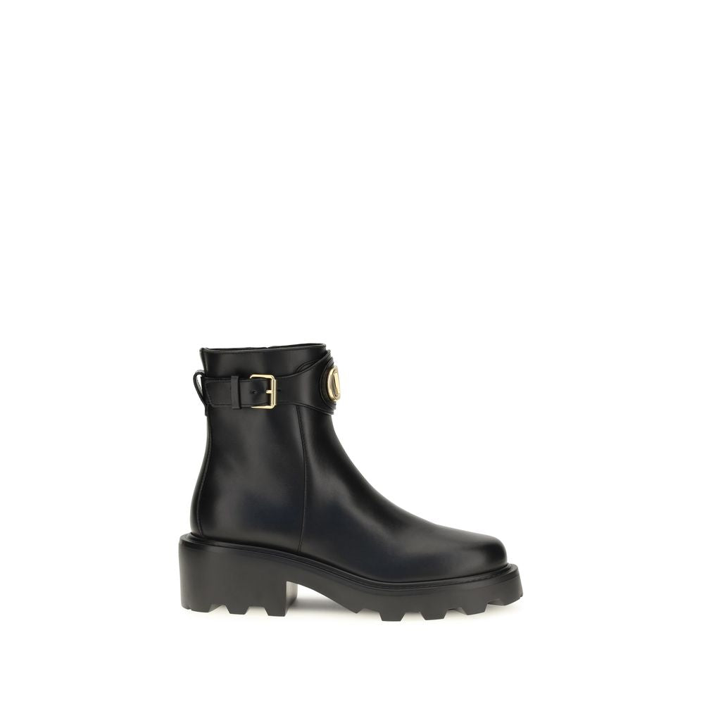 Black rain boot with a gold buckle on a white background