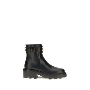Black rain boot with a gold buckle on a white background