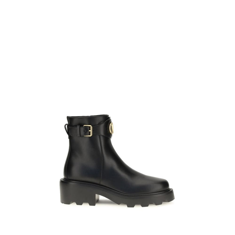 Black rain boot with a gold buckle on a white background