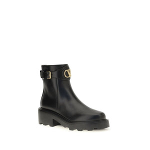 Black rain boot with gold buckle on a white background