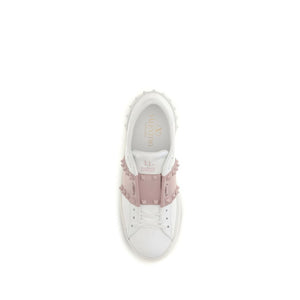 White sneaker with pink embellishments on a white background