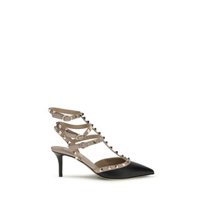 Valentino Garavani black calf leather pumps with beige cage straps, gold pyramid studs, and a stiletto heel.