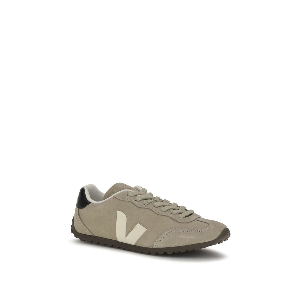 Beige suede low-top sneaker with white 'V' logo, black heel tab, and dark brown textured rubber sole.