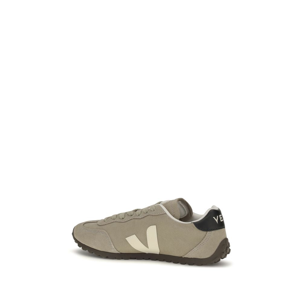 Beige suede sneaker with white "V" logo, black heel tab, and dark brown textured rubber sole, side view.