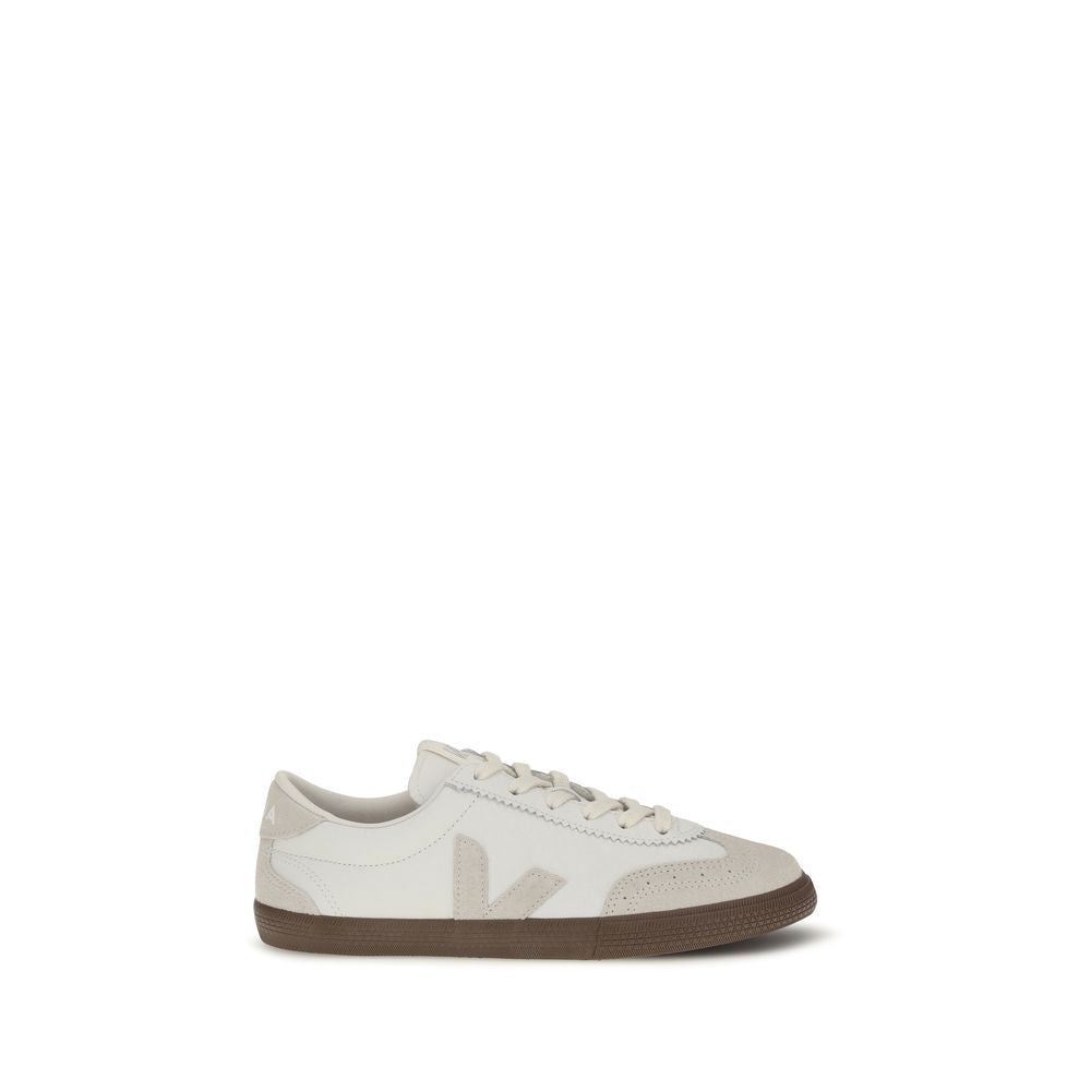 White and beige suede low-top sneaker with a dark gum rubber sole and side logo detail.