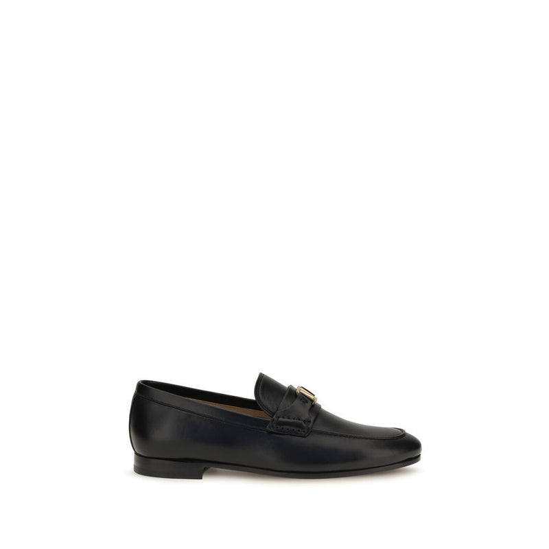 Black leather slip-on loafers with a low heel and metal accent