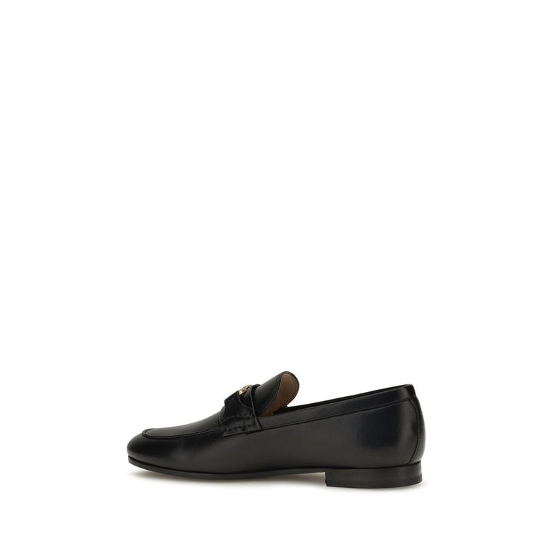 Black leather slip-on loafer with a low heel and strap detail