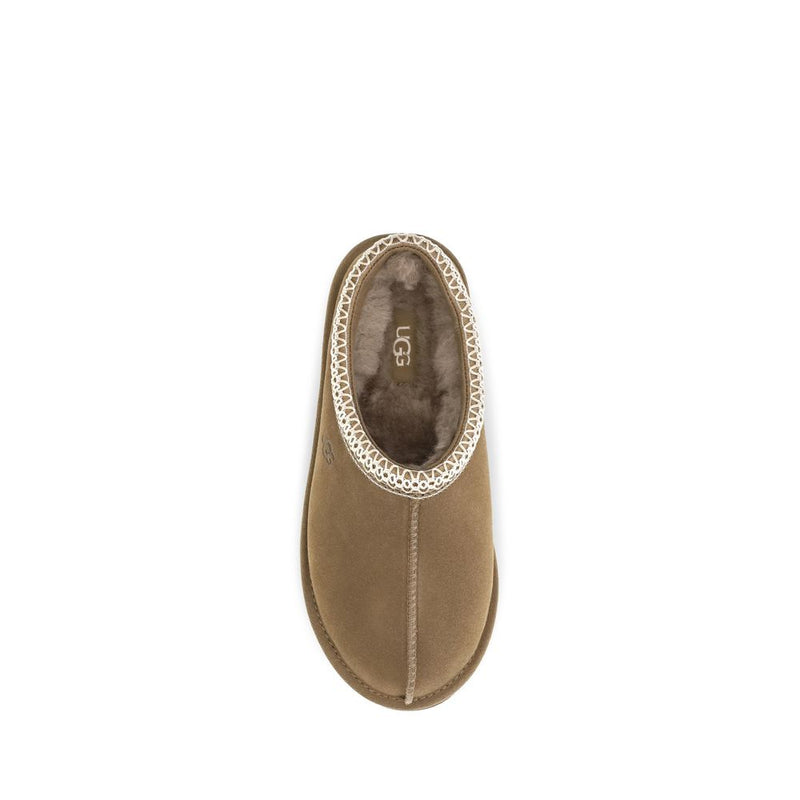 Beige suede mule with white whipstitching and plush shearling lining