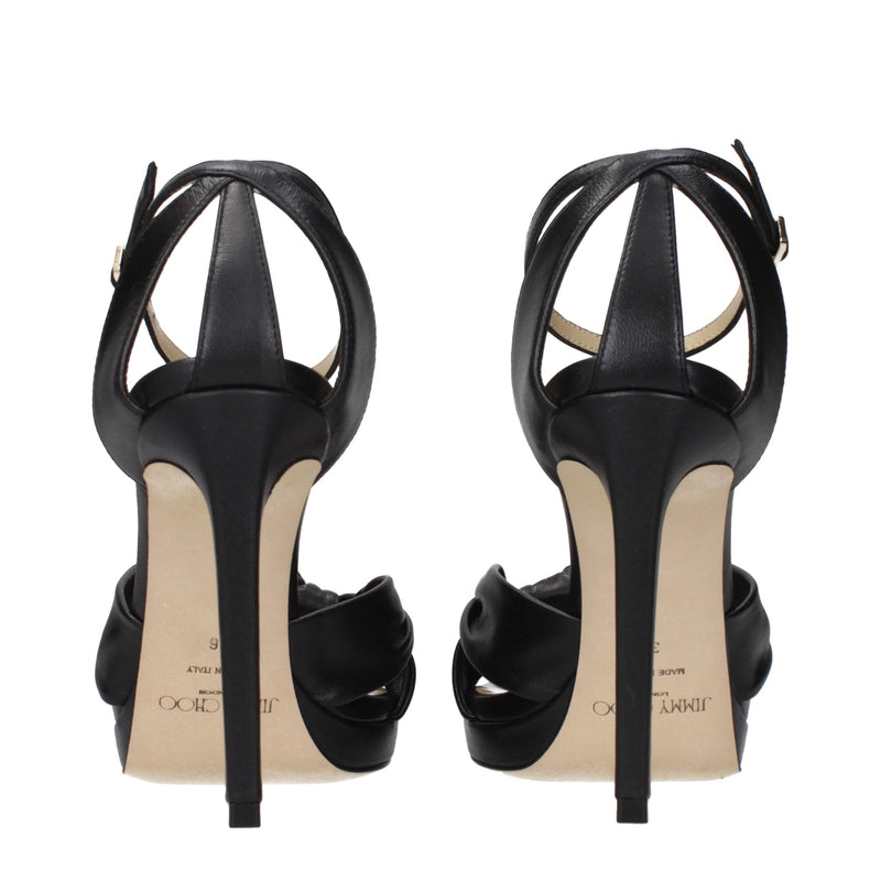 Pair of black leather platform sandals with high stiletto heels, seen from the back