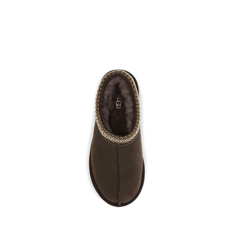 Dark brown suede UGG mule with plush fleece lining and decorative woven trim around the collar