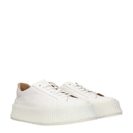 White leather platform sneakers with ribbed rubber soles and lace-up closure