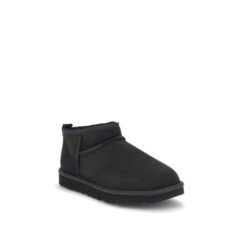 Black suede ankle boot with thick flat sole and exposed stitching