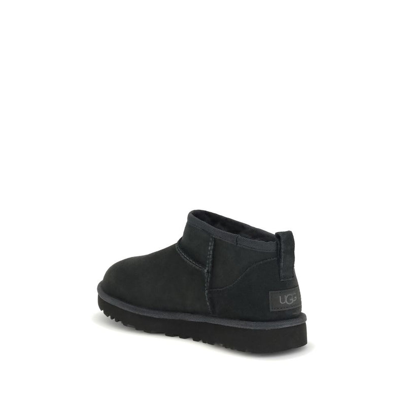 Black suede ankle boot with thick flat sole and UGG logo on the heel