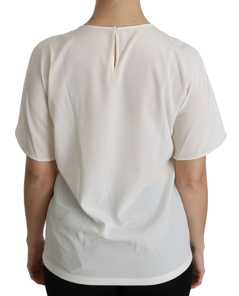 White silk short sleeve blouse with a round neckline and back button closure worn by a person
