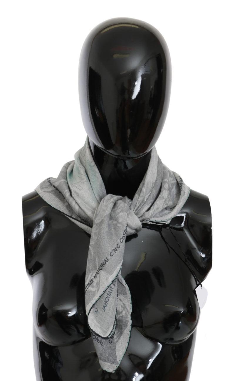 Gray silk foulard scarf tied around a black mannequin's neck with visible logo text