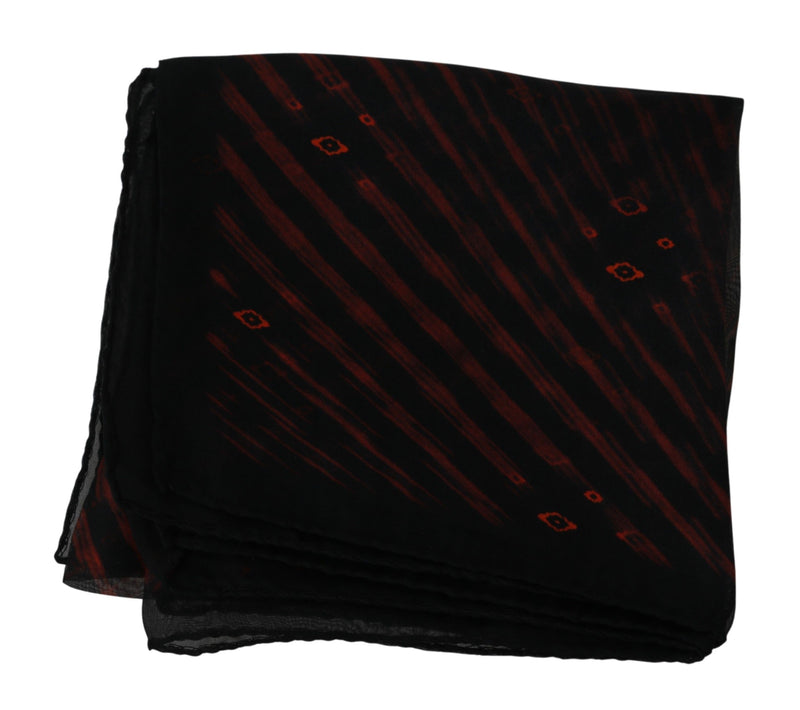 Folded black silk scarf with diagonal orange stripes and small geometric motifs