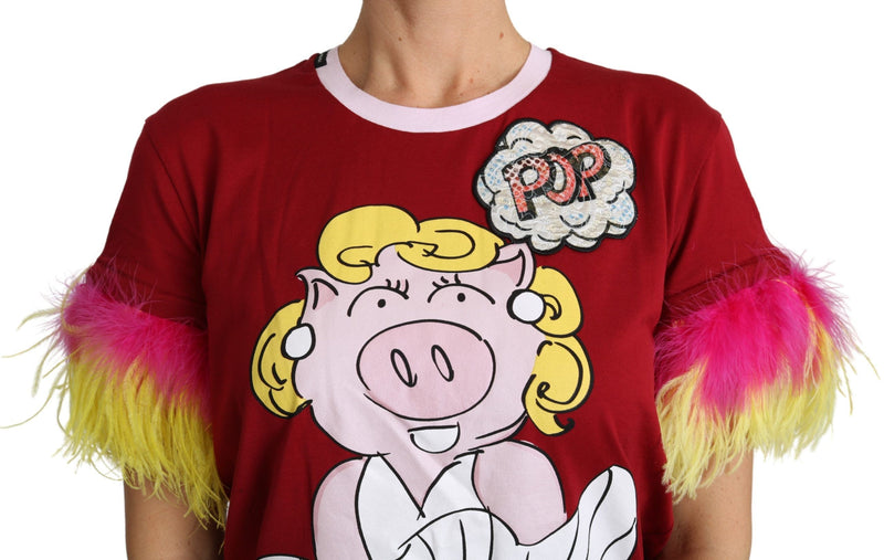 Red cotton t-shirt featuring a pig graphic and bright pink and yellow feather sleeve cuffs