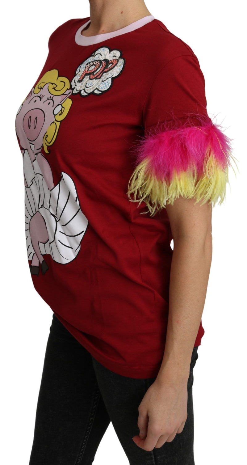 Red cotton t-shirt featuring a cartoon pig graphic on the front and vibrant pink and yellow feather sleeve cuffs