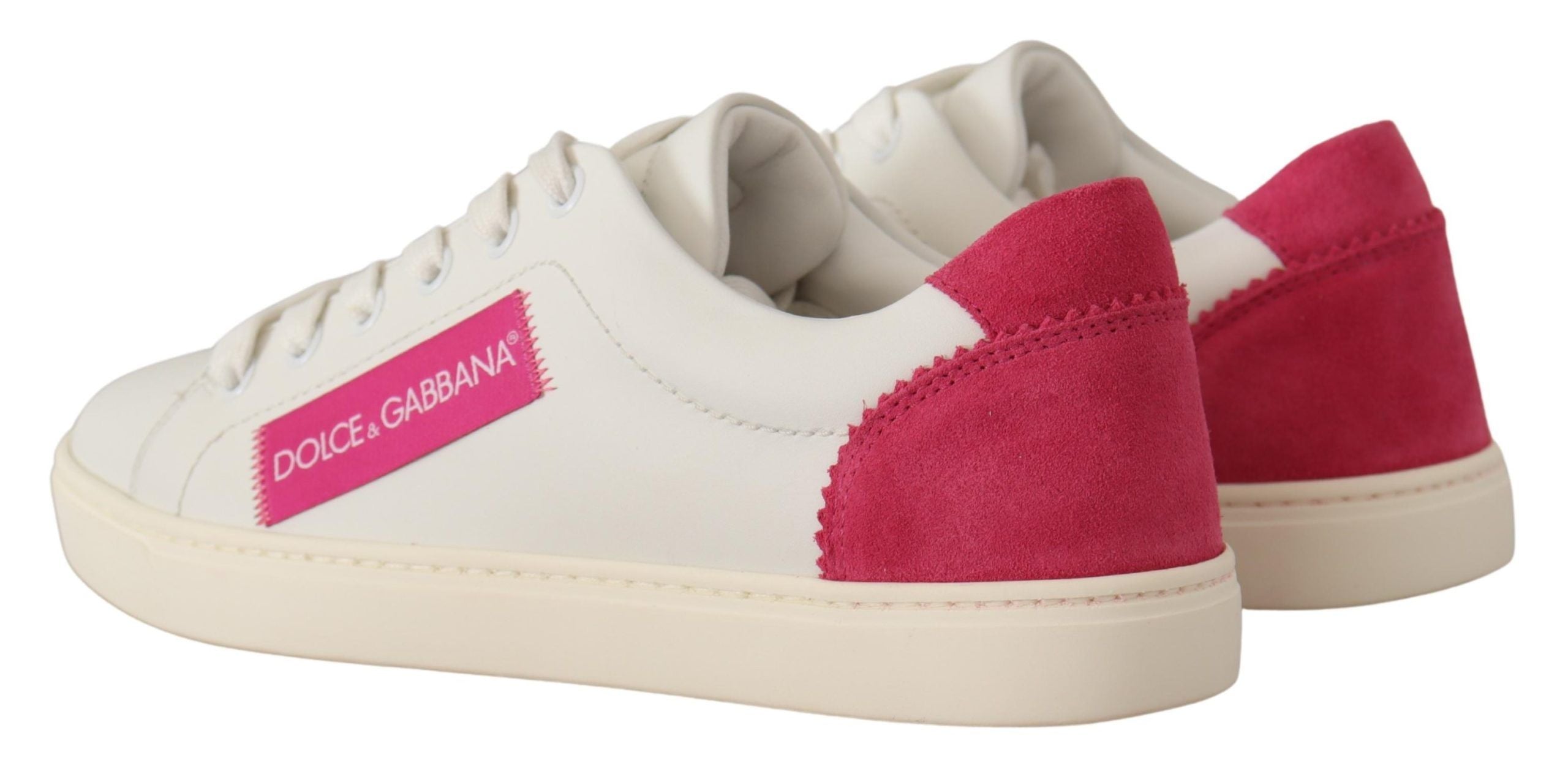 Dolce & Gabbana white leather low-top sneakers with pink suede heel tabs and pink logo patches on white rubber soles.