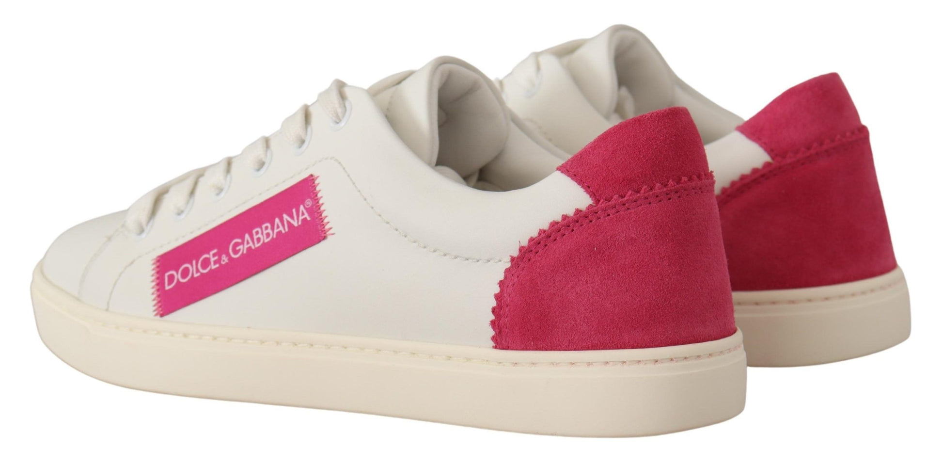 Dolce & Gabbana white leather low-top sneakers with pink suede heel tabs and pink logo patches on white rubber soles.