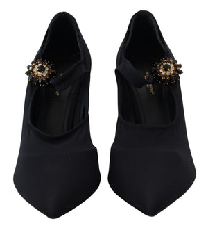 Black stretch fabric pumps with pointed toes, Mary Jane straps, and ornate black-and-clear crystal floral embellishments.