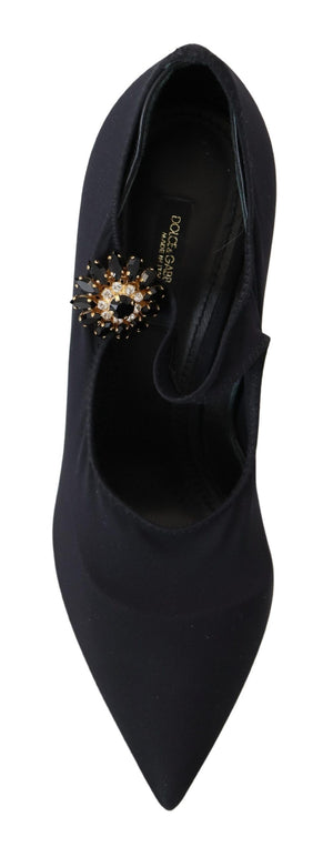 Black stretch fabric pump with a pointed toe and a large, ornate black-and-gold crystal floral embellishment.