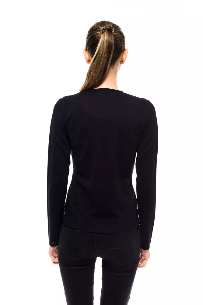 Back view of a woman wearing a long-sleeved dark blue wool crewneck sweater with black jeans
