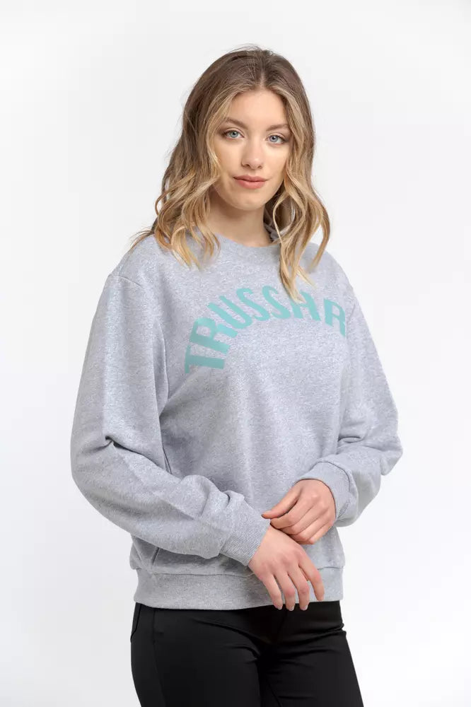 A woman wearing a gray cotton crewneck sweatshirt with light blue Trussardi lettering across the chest