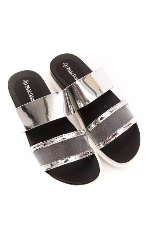 Péché Originel silver slide sandals with black footbeds, metallic straps, and grey mesh detail on a white sole.