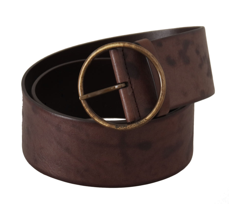 Dark brown wide leather belt rolled up with a round antique brass buckle