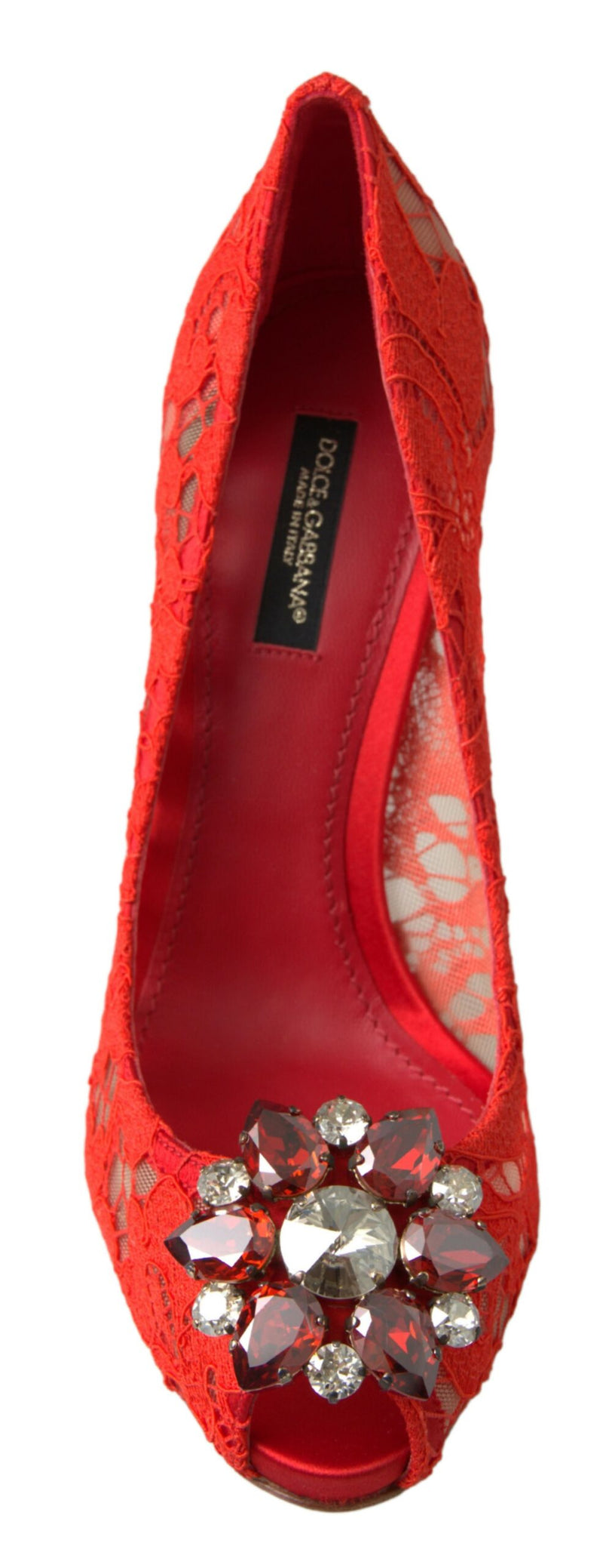 Red lace Dolce & Gabbana peep-toe pumps featuring a large, ornate flower-shaped cluster of red and clear crystals.