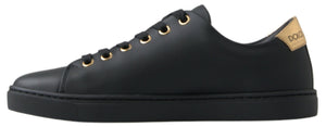 Black leather low-top sneaker with gold eyelets, black laces, and a gold branded heel tab on a black rubber sole.