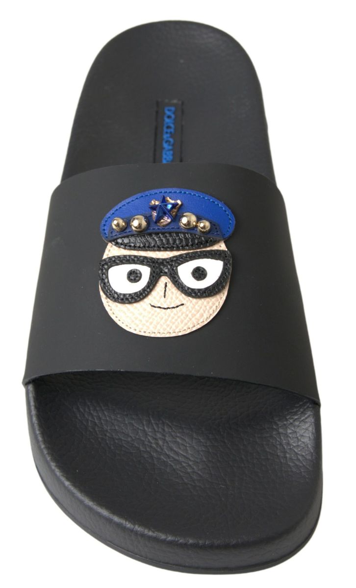 Black Dolce & Gabbana rubber slide sandal featuring a character patch with a blue police cap and glasses.