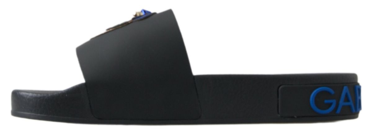 Black rubber slide sandal with a blue logo emblem on the strap and embossed blue logo lettering on the side.