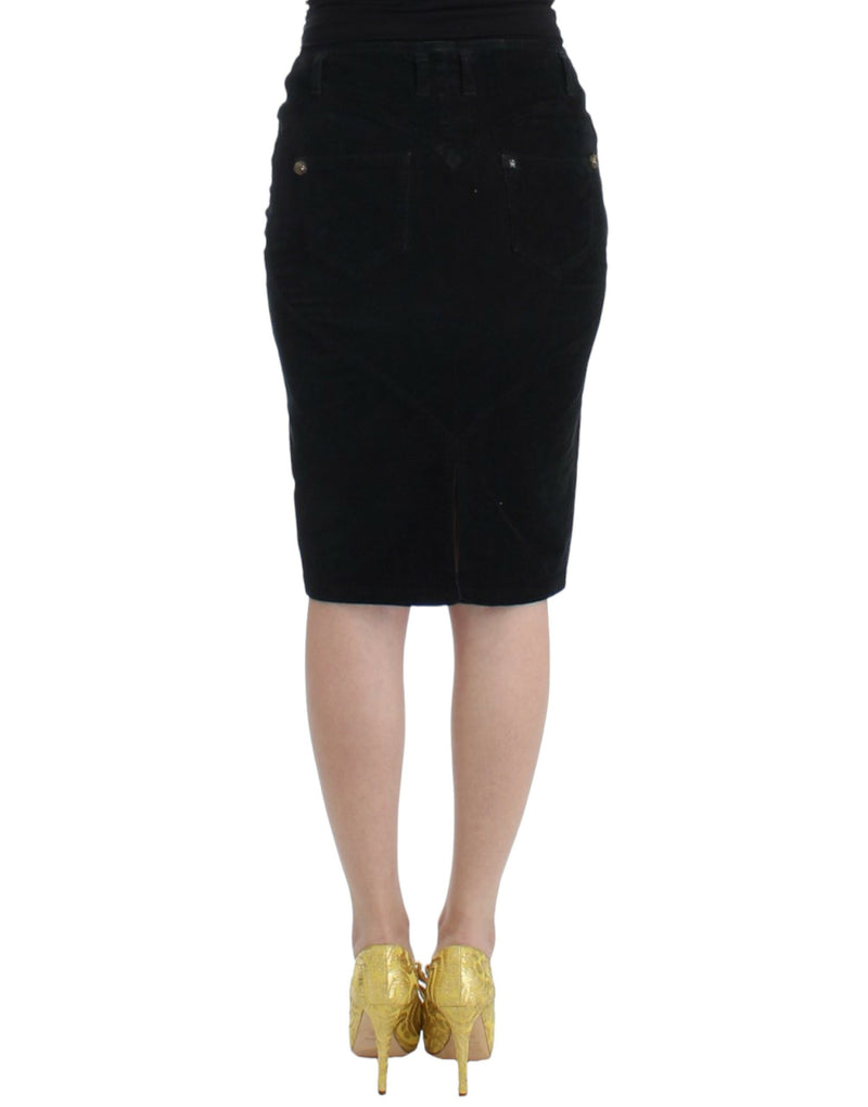 Black corduroy pencil skirt seen from behind, paired with gold heels