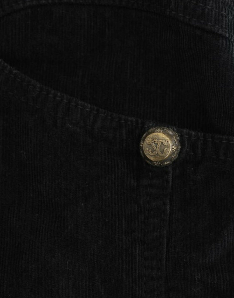 Close up of a black corduroy pencil skirt featuring an ornate gold button