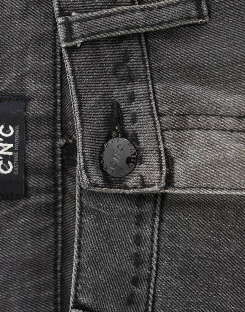 Close-up of gray denim jeans featuring a button fly and a black brand label