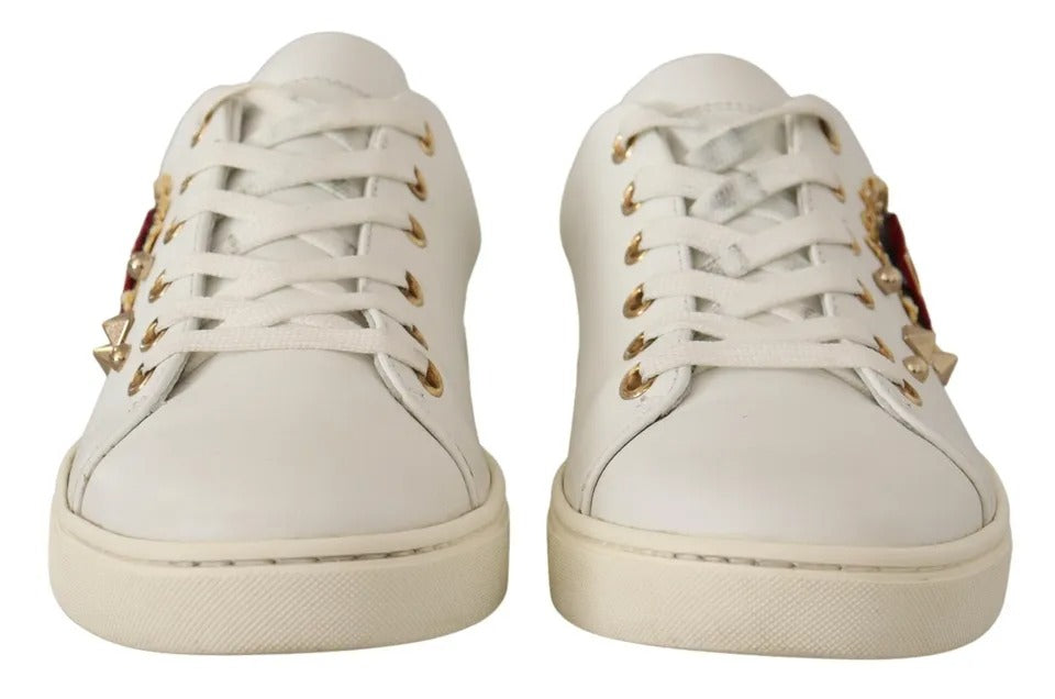 White leather Dolce & Gabbana lace-up sneakers with gold hardware and side red heart accents.